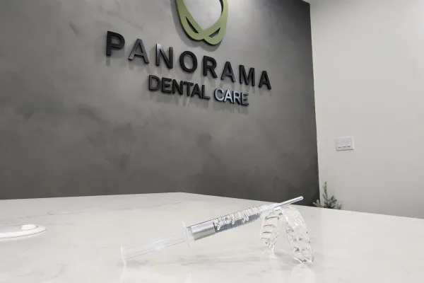 Modern textured accent wall featuring the dimensional corporate signage for Panorama Dental Care with a syringe of take home whitening gel centered